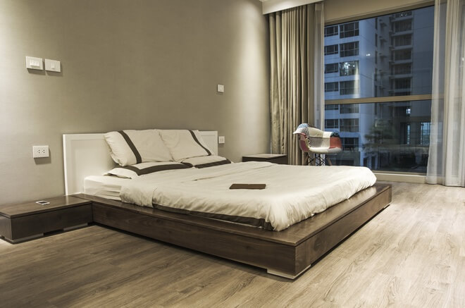 Phòng ngủ chính sử dụng tủ đồ và giường có thiết kế gọn gàng tạo cảm giác nhà rộng thoáng hơn sau khi cải tạo căn hộ chung cư.